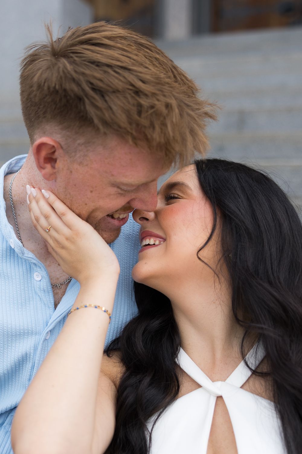 A romantic couple shares an intimate moment while standing outdoors.