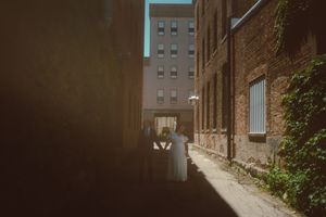 Architectural view of a brick alleyway with dramatic shadows and lighting.