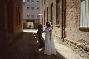 Sun-drenched urban alley with historic brick buildings creating a romantic backdrop.