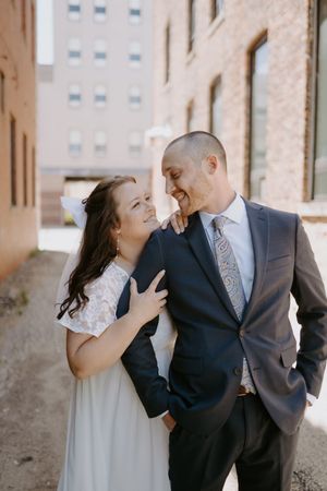 Playful wedding portraits captured in a historic brick passageway.