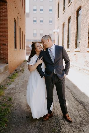 A couple shares intimate moments during their wedding photoshoot in an industrial setting.
