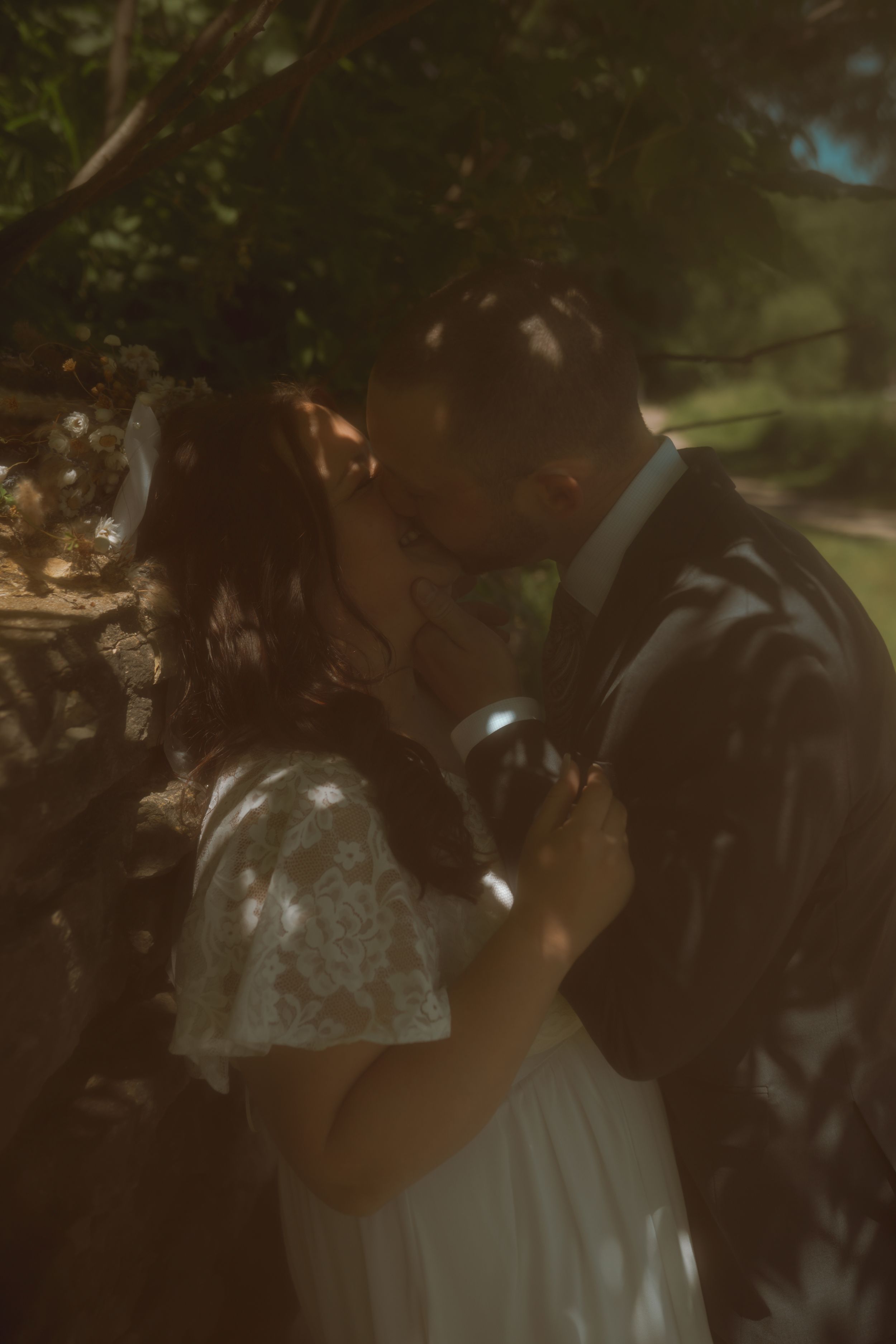 Intimate wedding portrait session with soft lighting and natural greenery in the background.