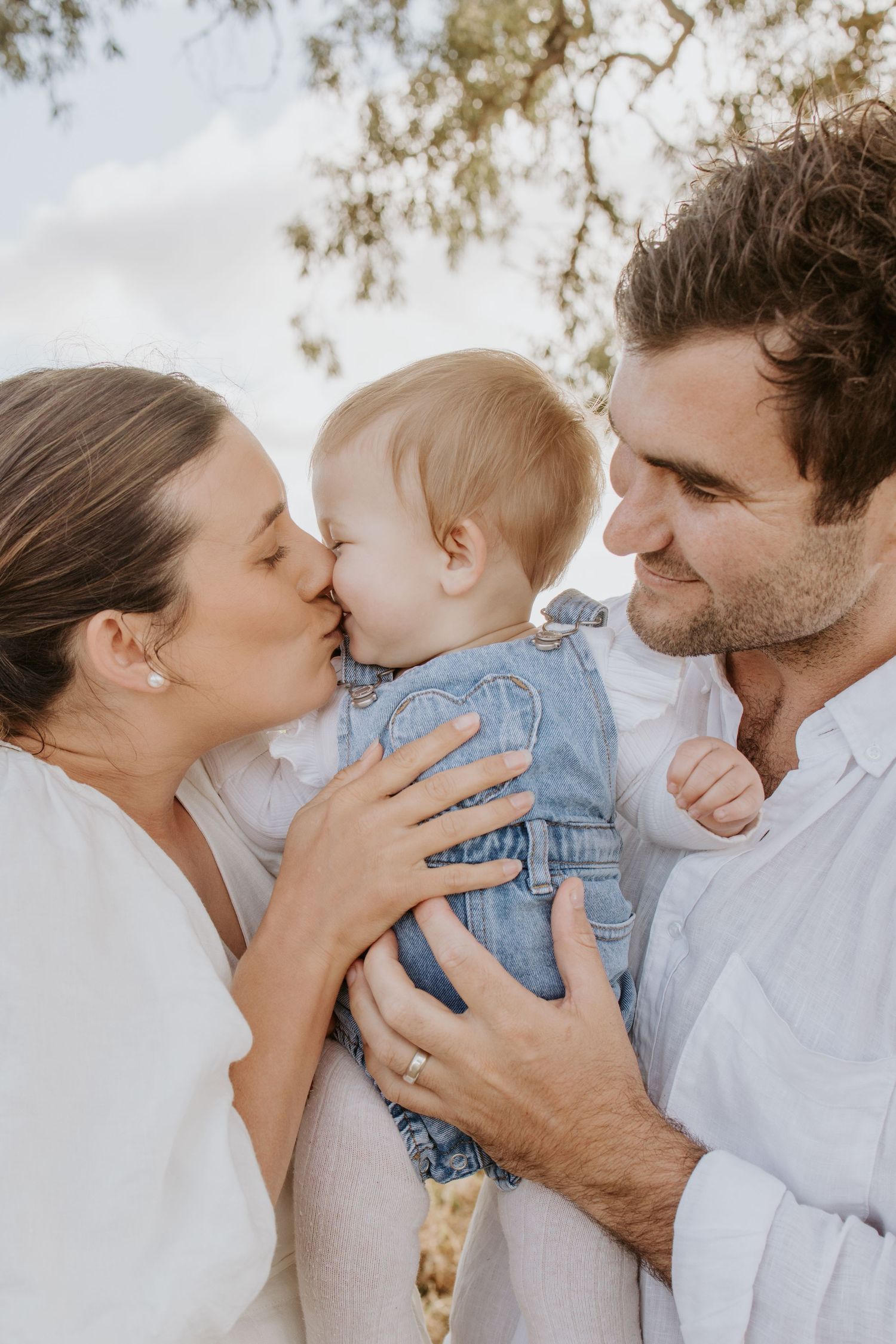 Parents and child sharing a tender moment in a family photo session in McLaren Flat.