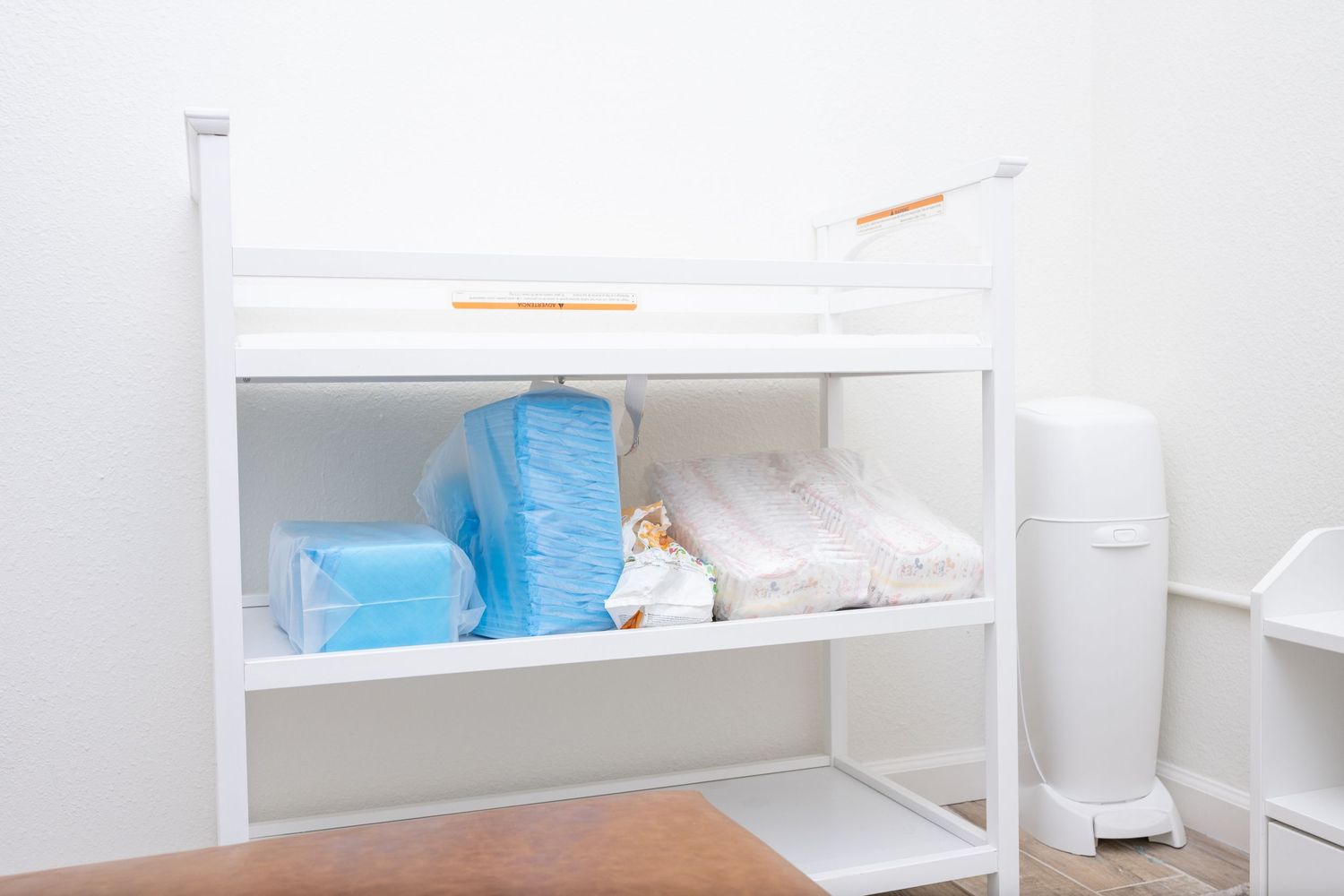 White storage shelf with medical supplies and hygiene products.