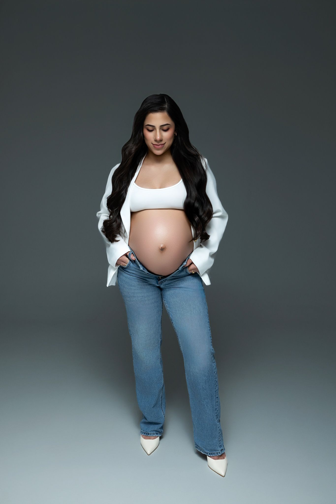 A series of artistic maternity portraits featuring a flowing deep red tulle gown against a textured gray backdrop.