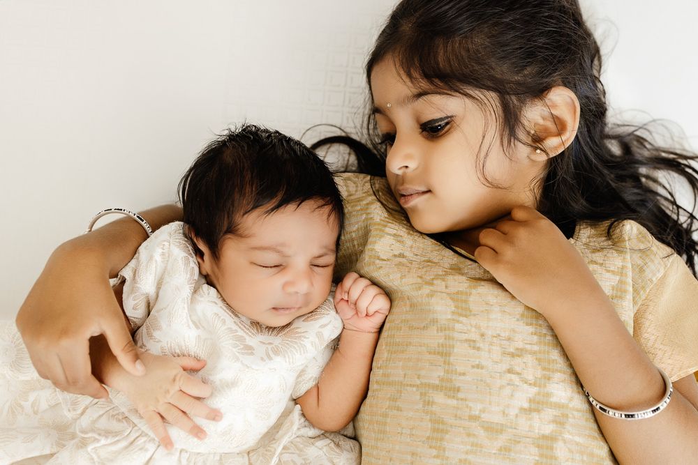 Sisters share a cuddle at in-home Bay Area newborn photography session