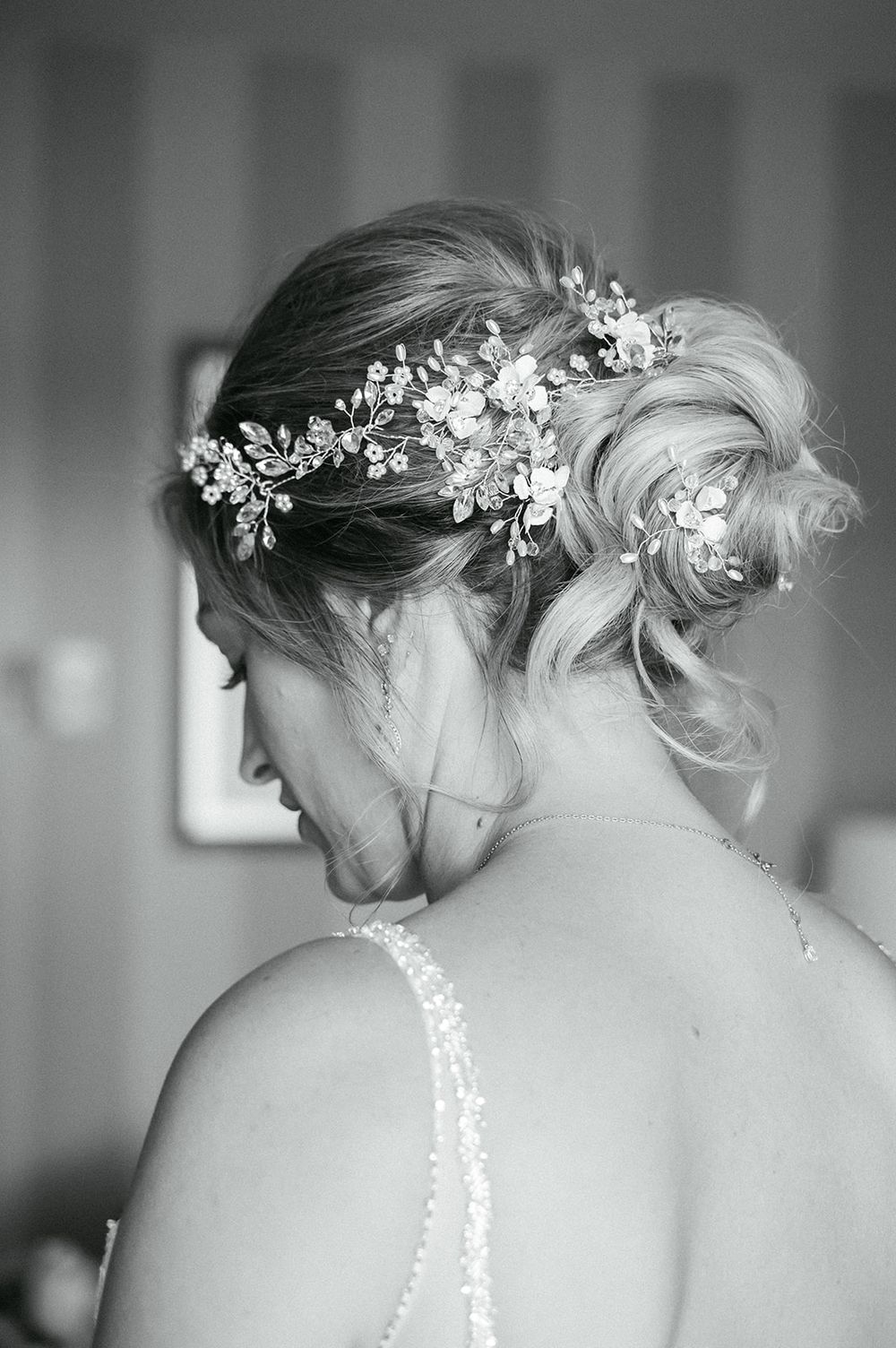 Close-up shots of delicate floral hair accessories and bridal details in black and white.