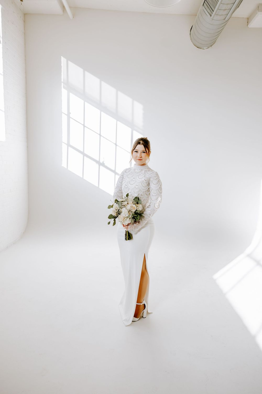 Minimalist bridal portraits in a bright white studio space with natural window light.