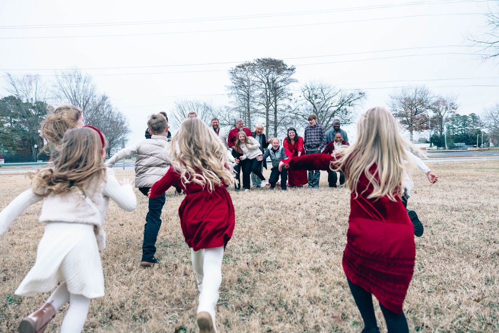 Kids running together in an open field during winter.