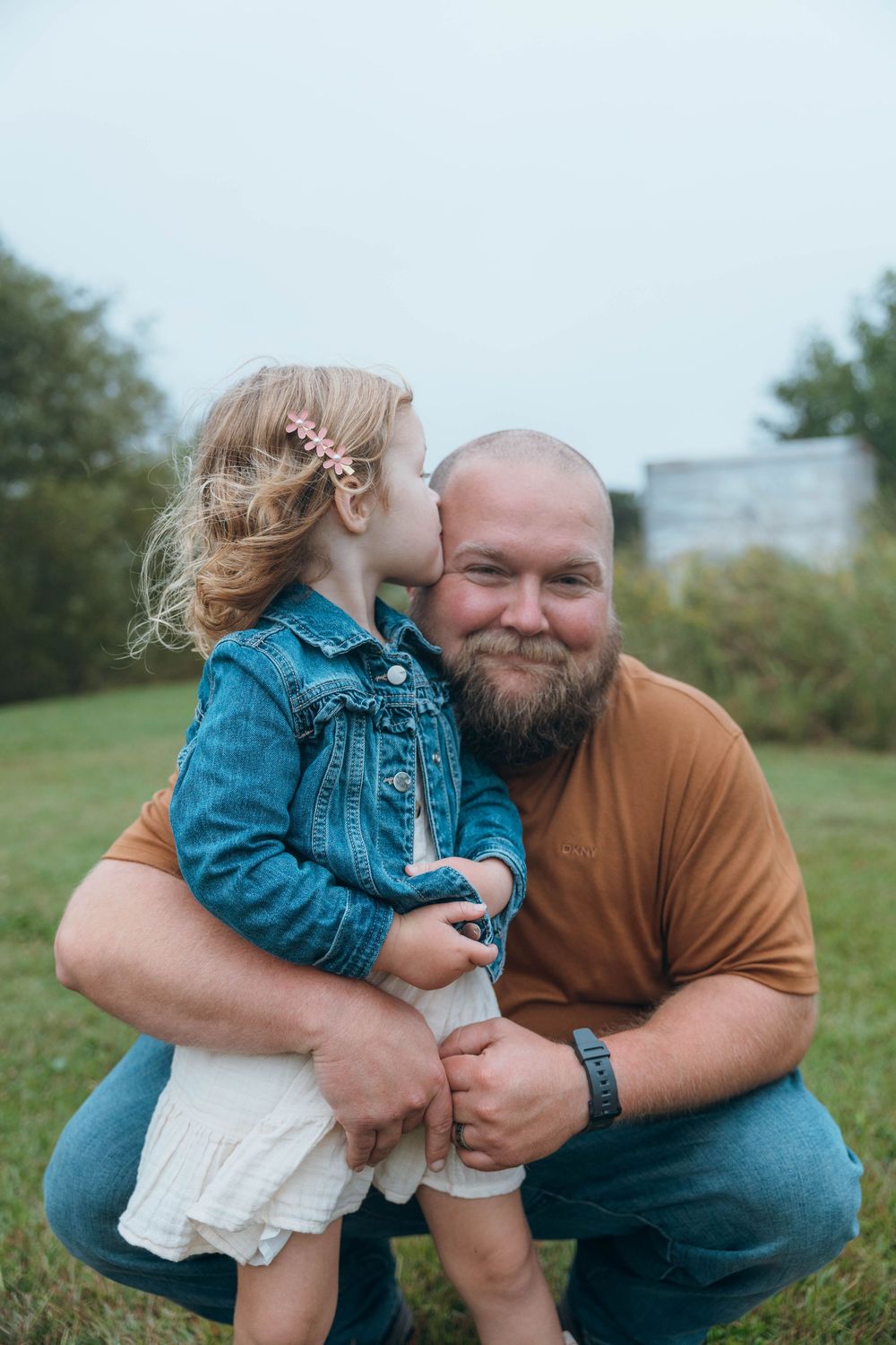 Happy family smiling together during a relaxed outdoor family photography session in North Carolina.