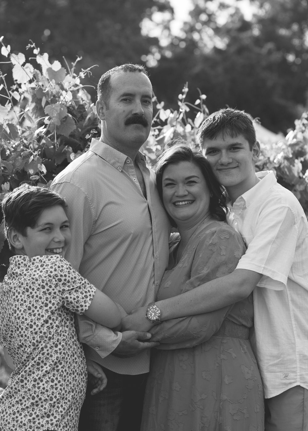 Happy family smiling together during a relaxed outdoor family photography session in North Carolina.