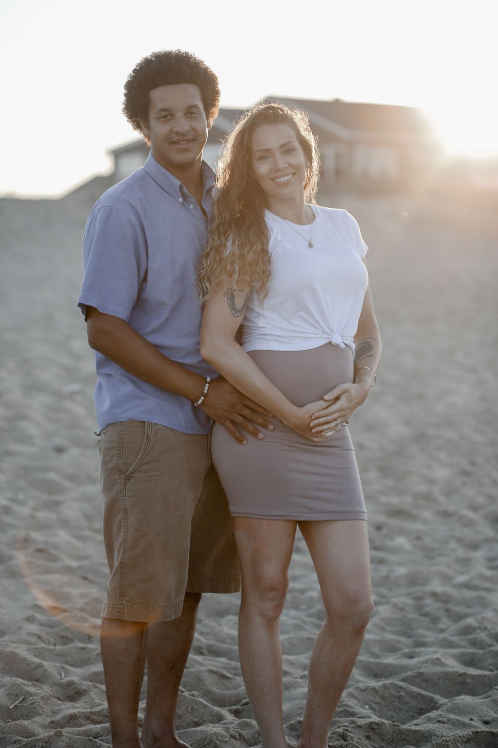 Expecting mother holding baby bump during a glowing maternity photography session with natural light in North Carolina.