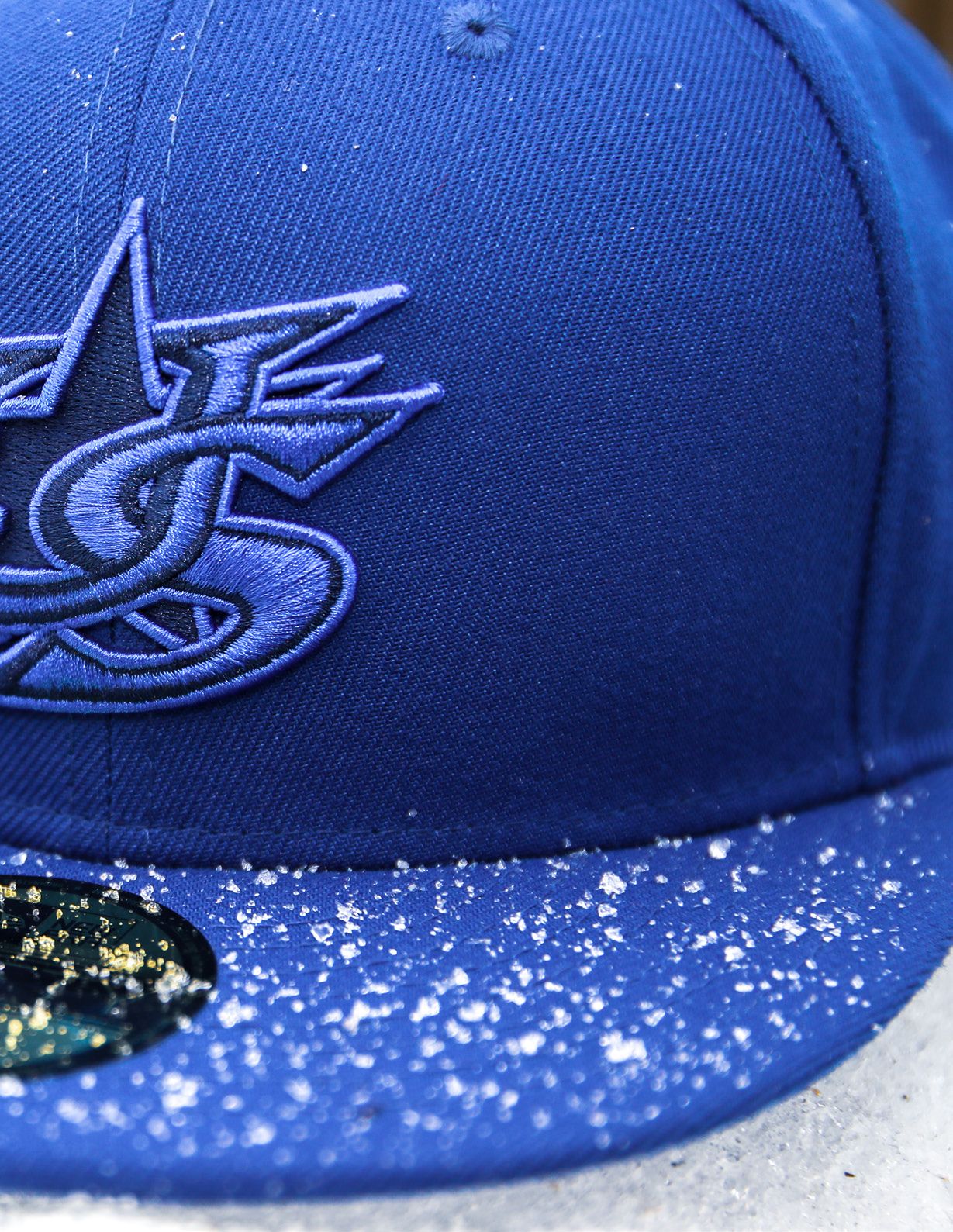 Close-up of a royal blue New Era fitted cap with embroidered USA Baseball star logo and glitter brim detail.