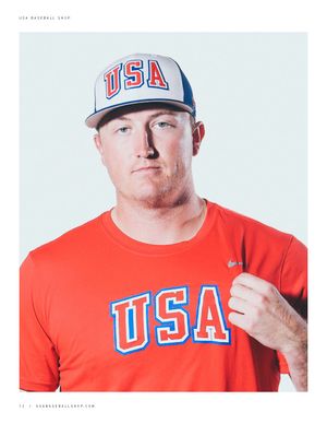 Baseball player wearing white USA New Era snapback cap and red Nike USA Baseball t-shirt in lookbook photo.