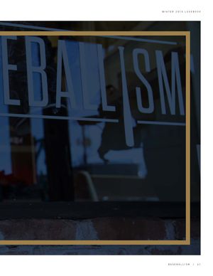 Dark moody reflection of Baseballism store sign photographed through glass window.