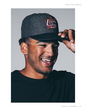 Smiling man wearing a grey herringbone New Era USA Baseball fitted cap with red and blue embroidered logo.