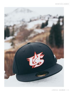 Black New Era USA Baseball 59Fifty fitted cap with red and white embroidered star logo resting on snow outdoors.