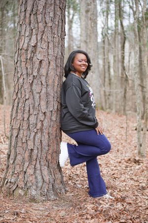 Four sequential photos show someone in navy pants and black hoodie posing thoughtfully against pine trees in autumn.
