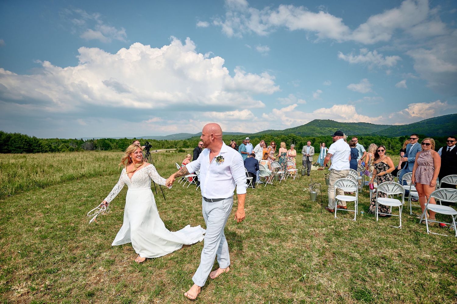 Newly married couple walking shoeless from the altar with Blue Ridge Mountains backdrop at Canaan Valley.