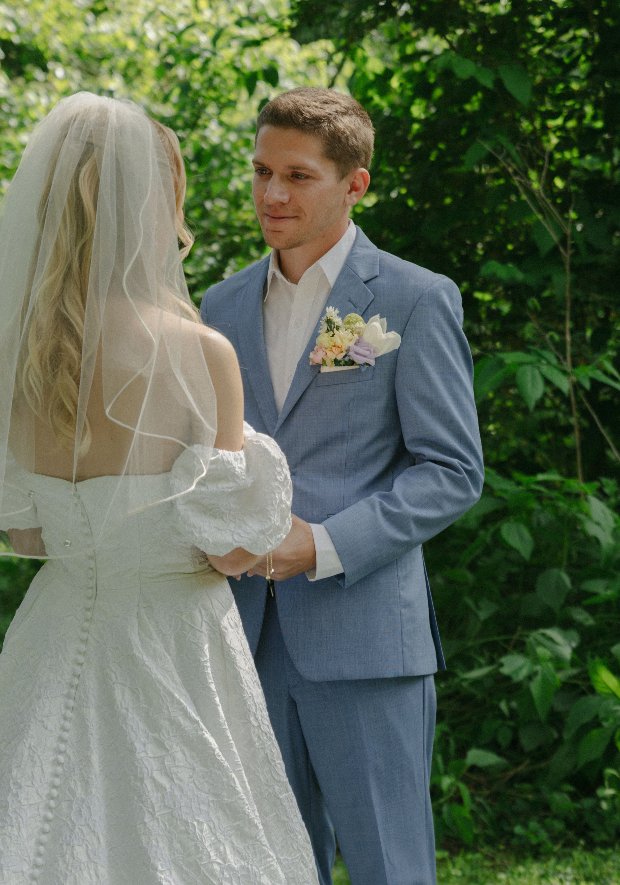 Intimate moment between bride and groom during garden wedding ceremony.