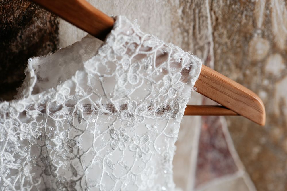 Close-up detail of delicate white lace trim being crafted with a wooden stick into intricate patterns.