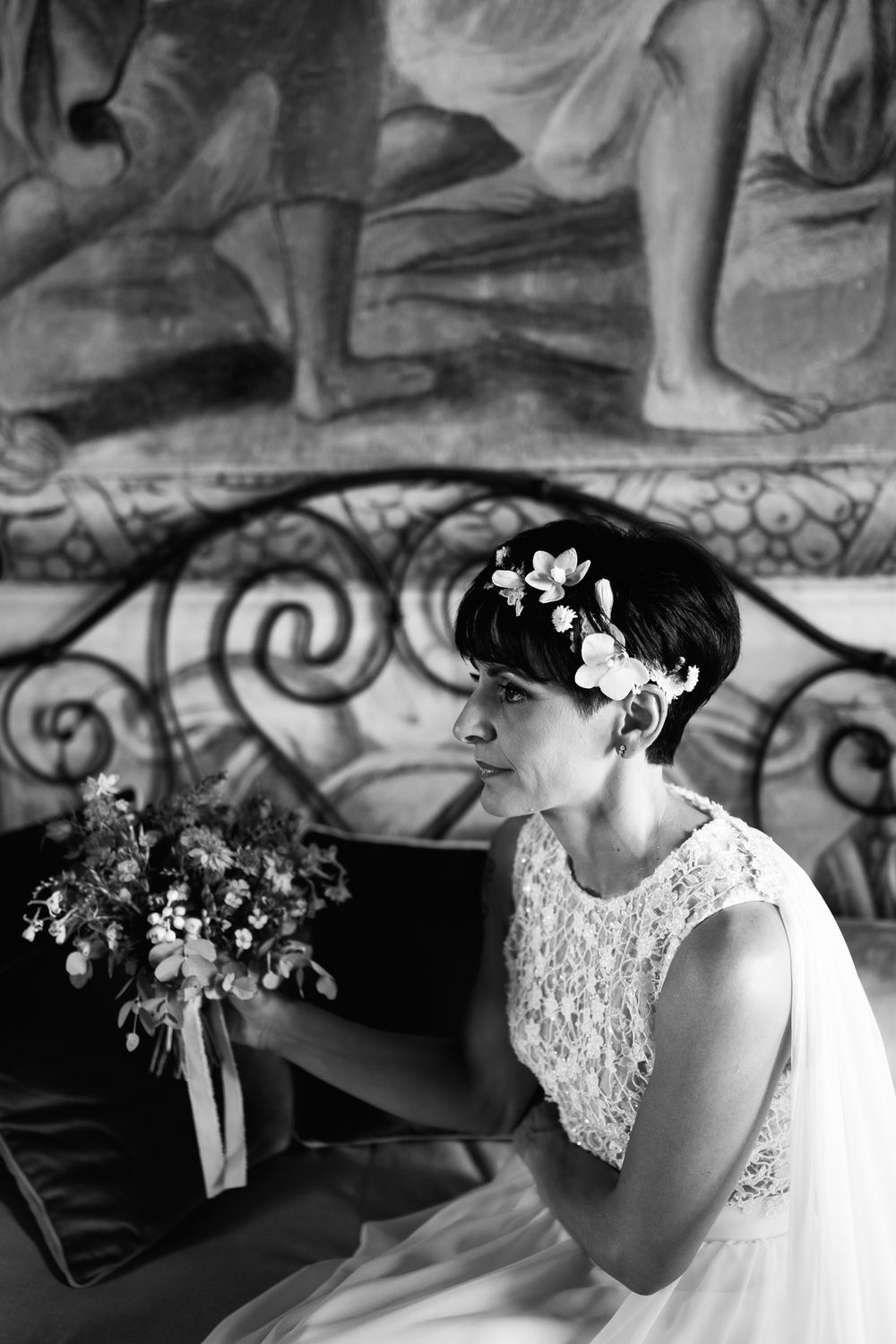 Close-up artistic black and white shots of a bride wearing a lace wedding dress and floral headpiece.