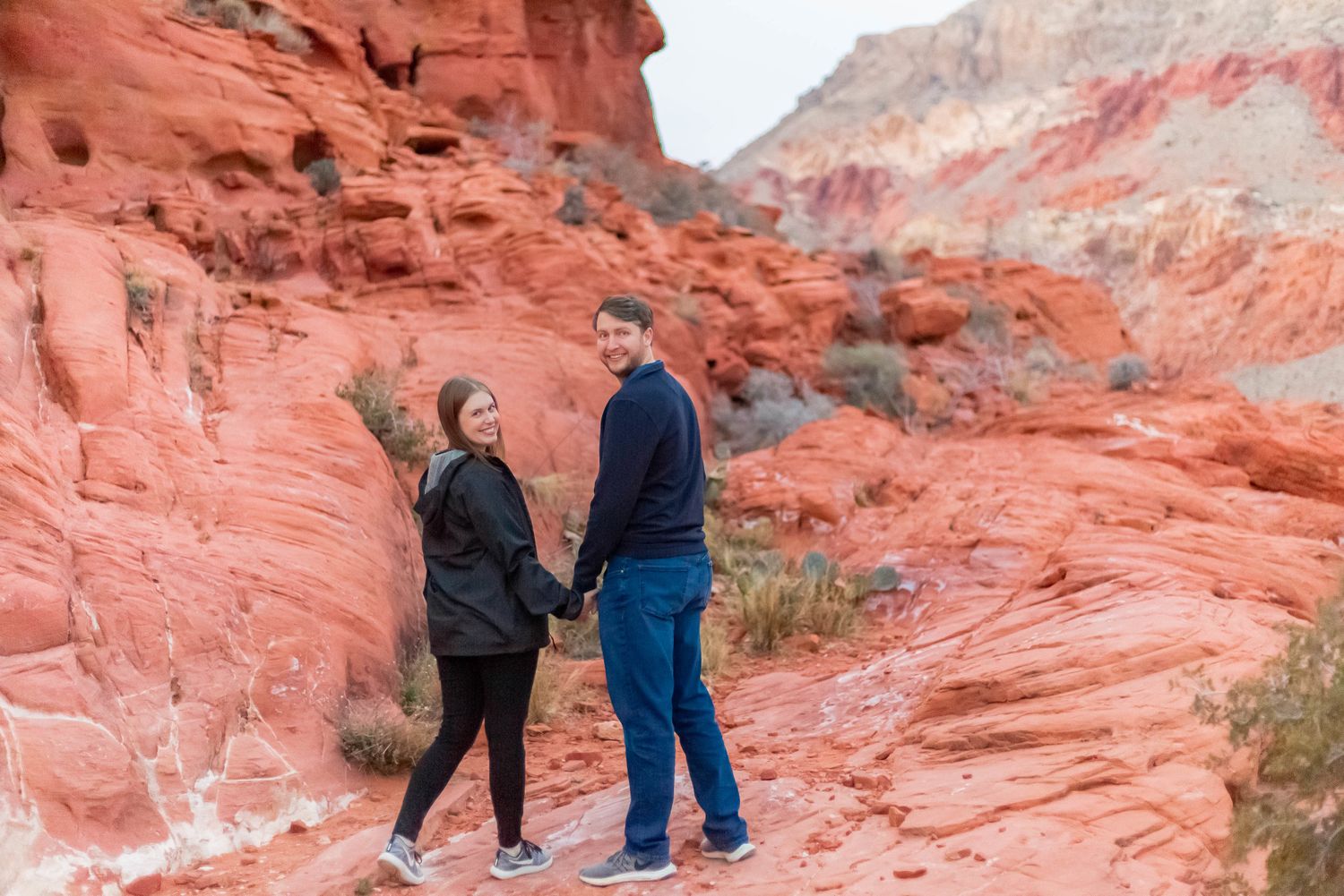 Two people enjoying the scenic red rock formations at Valley of Fire State Park in Nevada.