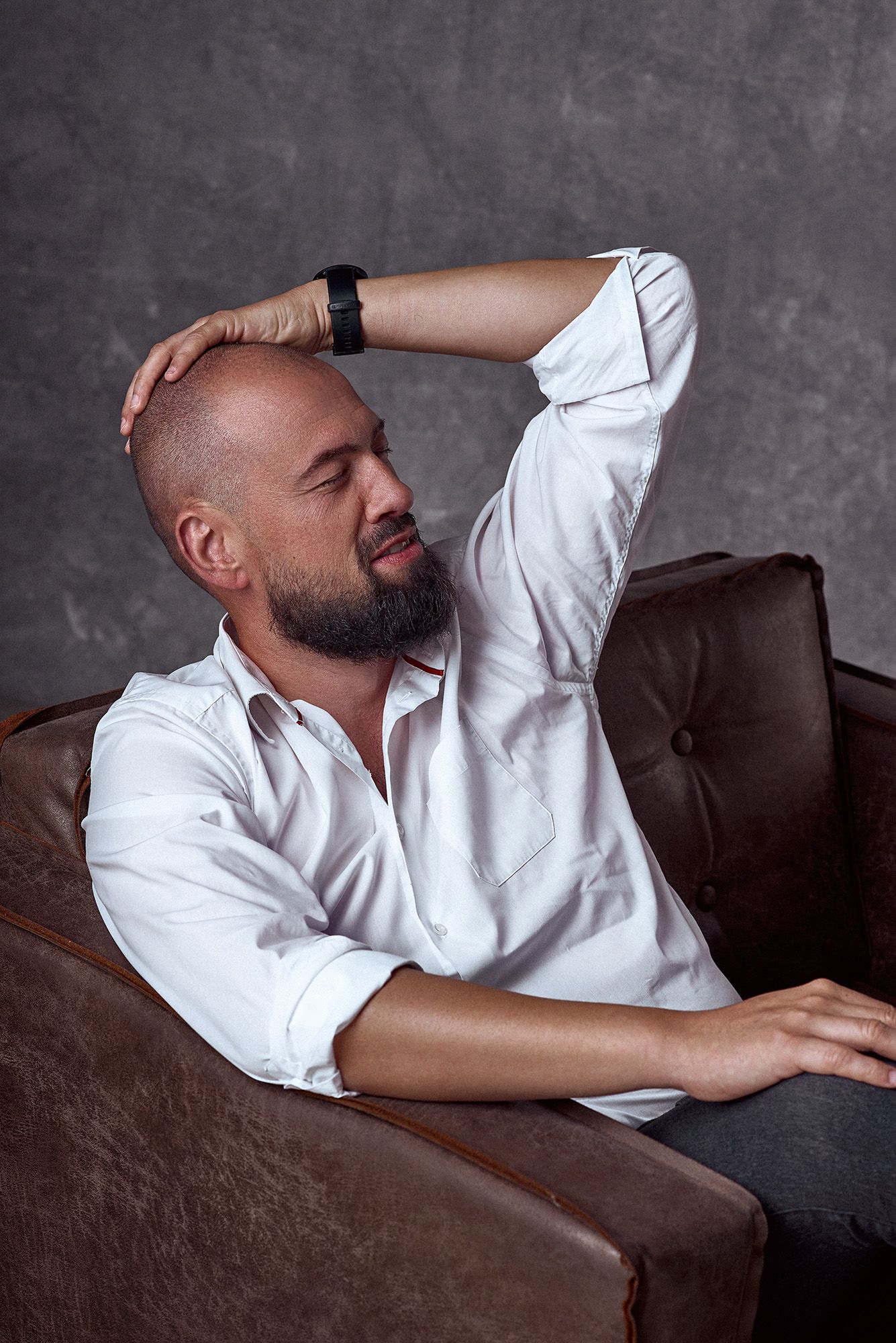 Portret mężczyzny w białej koszuli na skórzanym fotelu, fotografia wizerunkowa autorstwa Anety Ludwig. Personal branding premium.