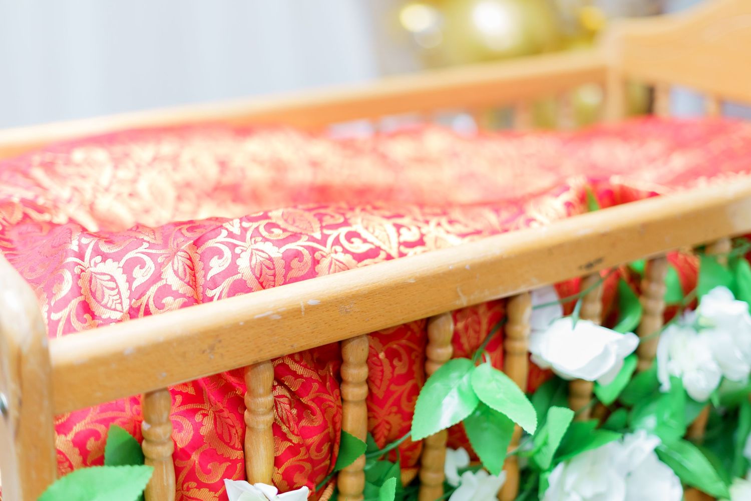 A close-up view of a pink and red patterned fabric roll with green tissue paper underneath.