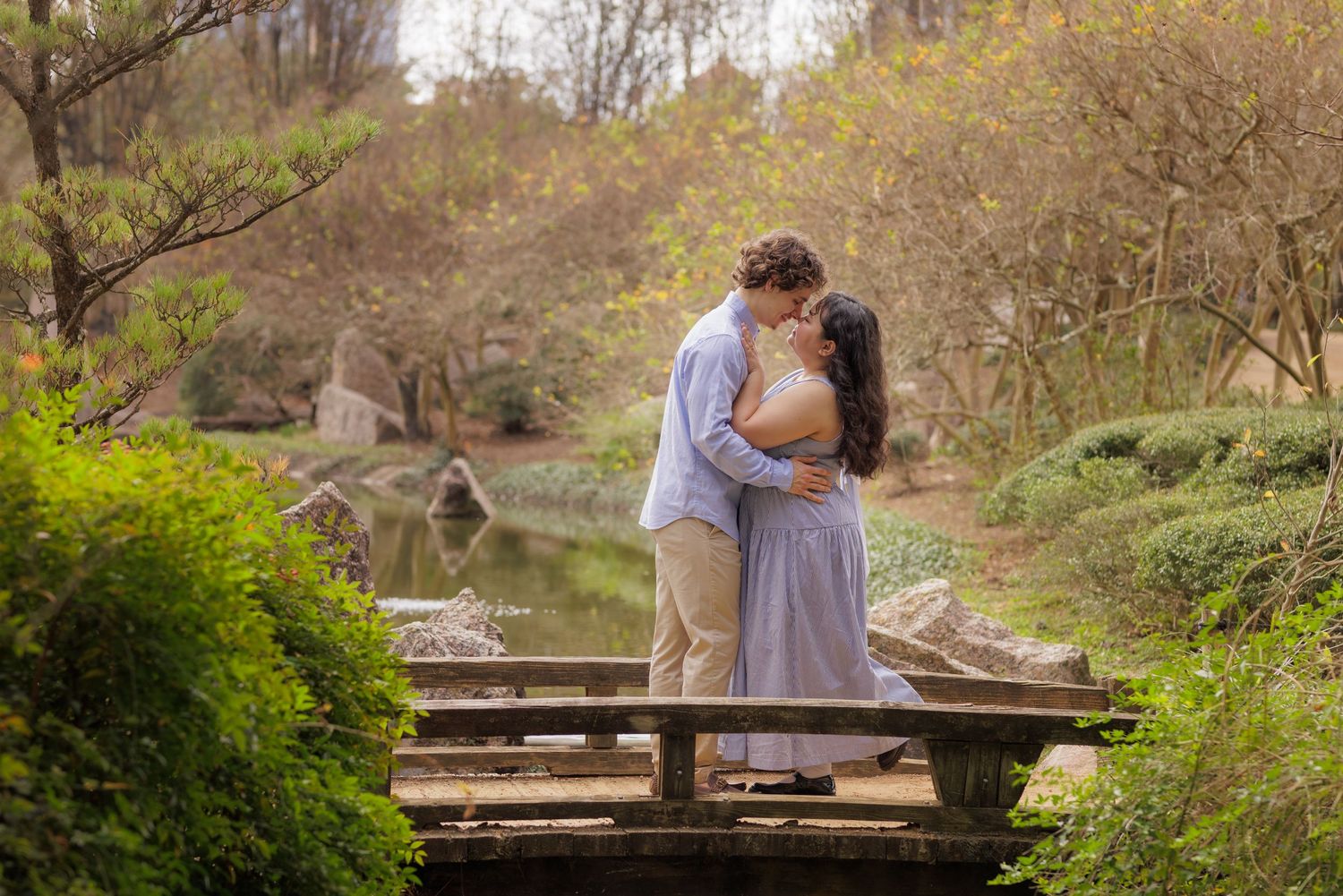 Couple portrait session in a blue bonnet field holding hands and mesmerizing into each other's eyes.