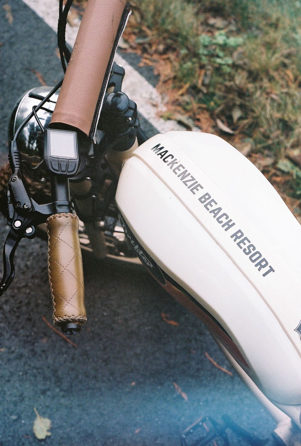 Close-up detail of a motorcycle handlebar showing Mac headunit branding.