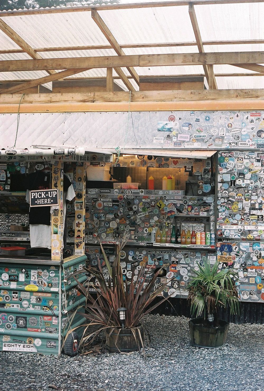 Outdoor covered space with walls covered in stickers and memorabilia.