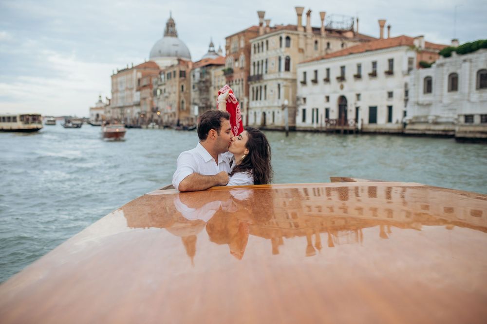 A romantic moment on a wooden water taxi cruising along the iconic Grand Canal in Venice, Italy.