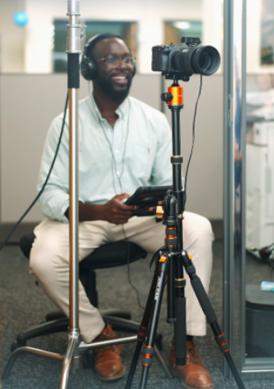 Professional photo studio setup with track lighting, light stands, camera equipment and a teal accent wall in modern space.
