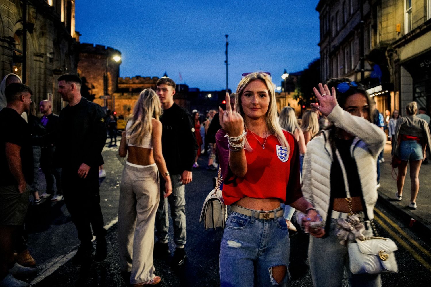 People enjoying a lively evening on a city street with warm lighting and festive atmosphere.