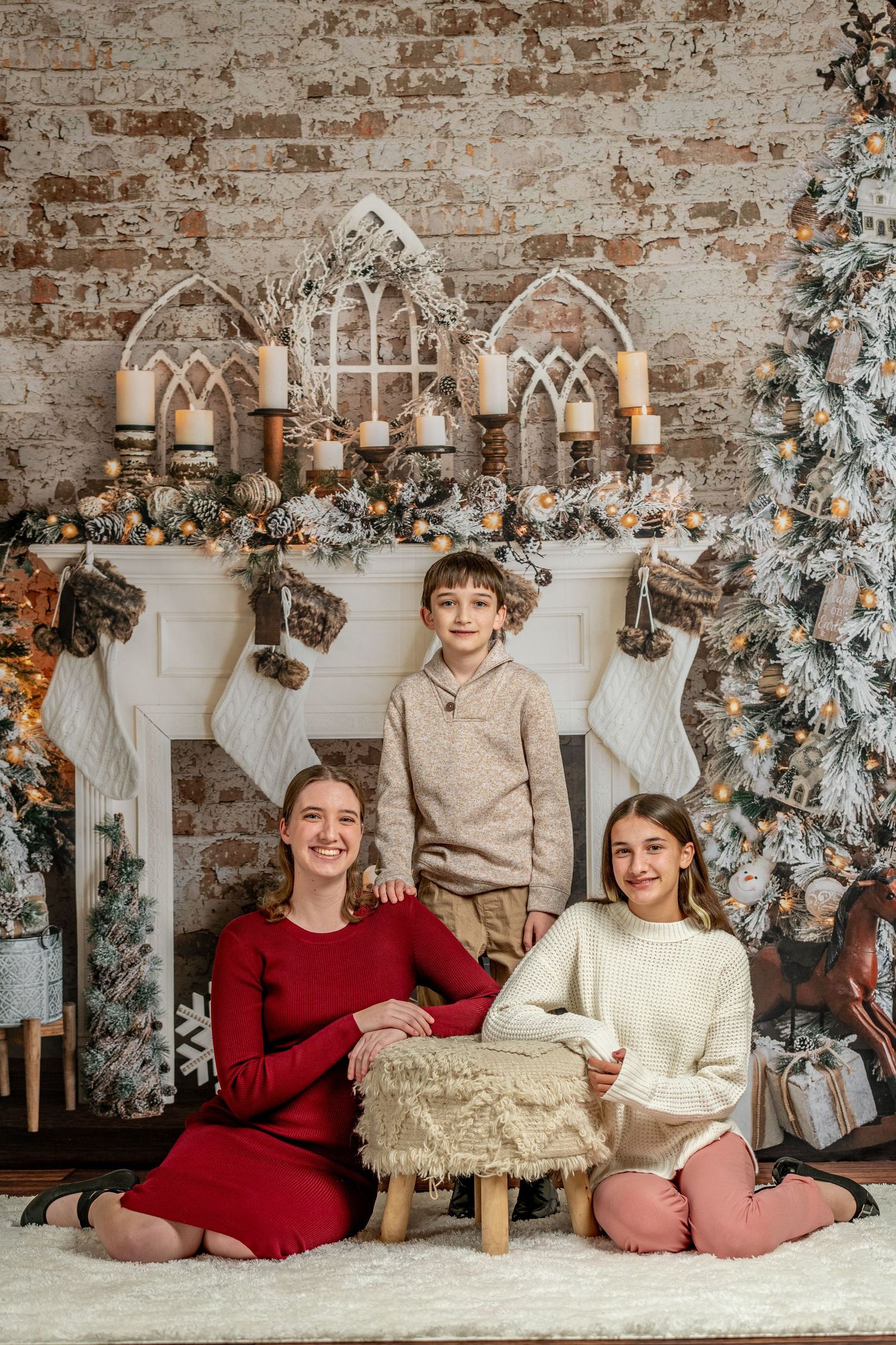 Family holiday portrait in front of decorated Christmas fireplace with gothic arches.