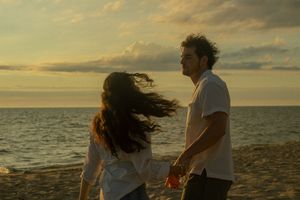 A couple plays and spins on the beach for couples photos in Saugatuck, Michigan.