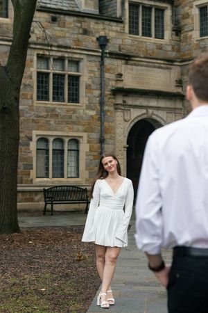 A couple looks at each other at the Law Quad in University of Michigan in Ann Arbor during their engagement photos.