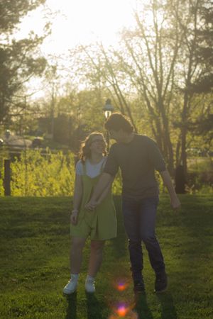A couple plays and walks during golden hour at a park in Downtown Flushing, Michigan.