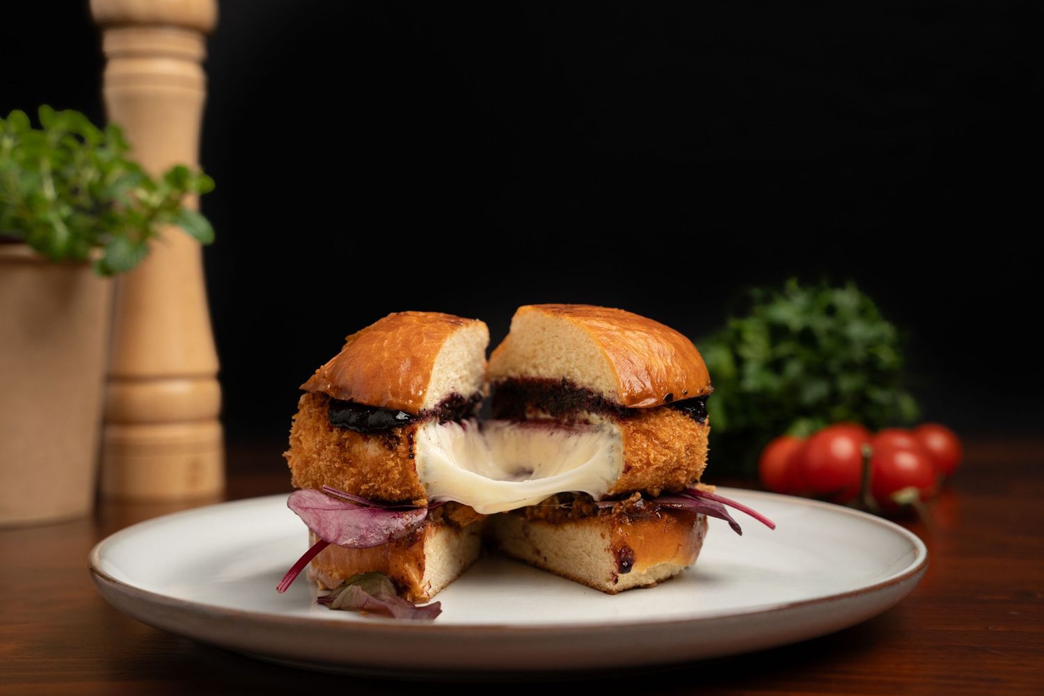 Slider sandwiches with melted cheese and meat on white plate with garnish.