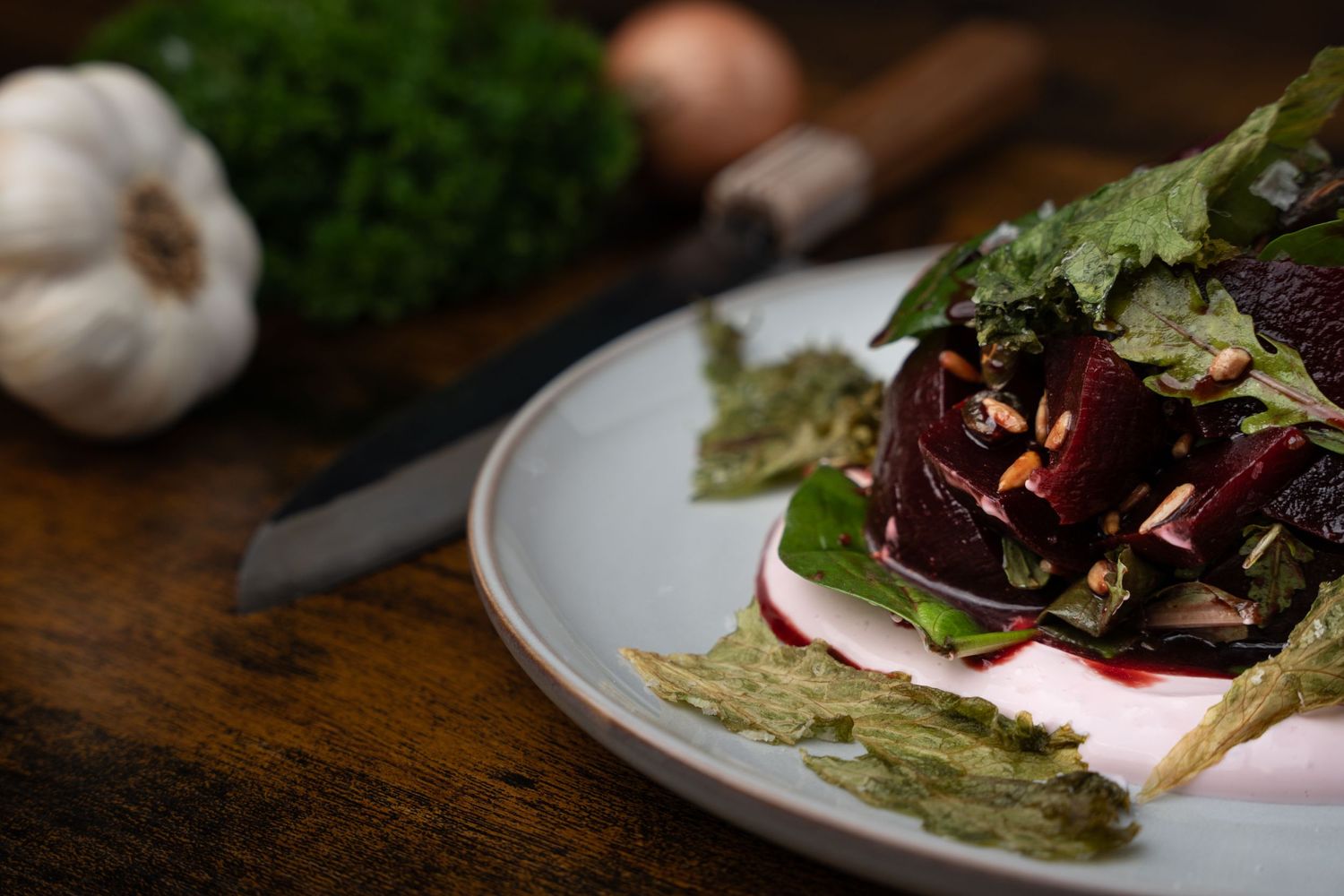 Fresh salad with beets and greens plated elegantly on rustic wooden table.