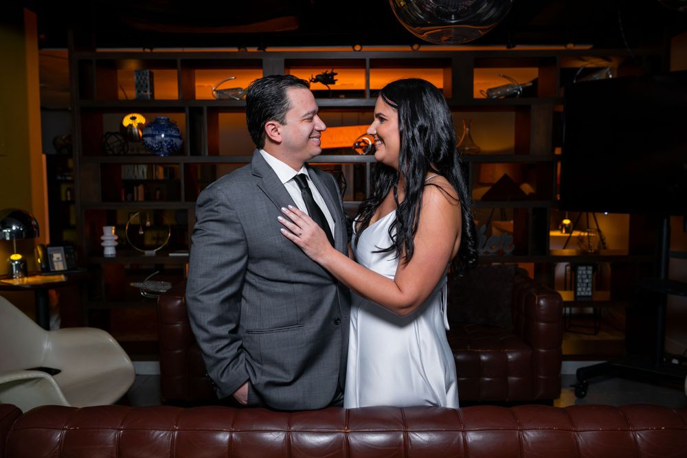 Couple sharing romantic moment at upscale bar with warm ambient lighting.