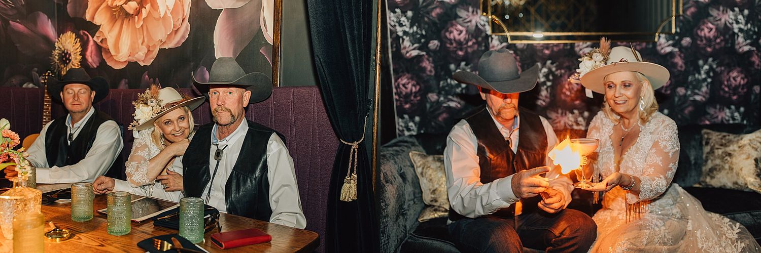 Couples in Western cowboy attire celebrate at a rustic venue with floral wallpaper, candlelight, and vintage decor.