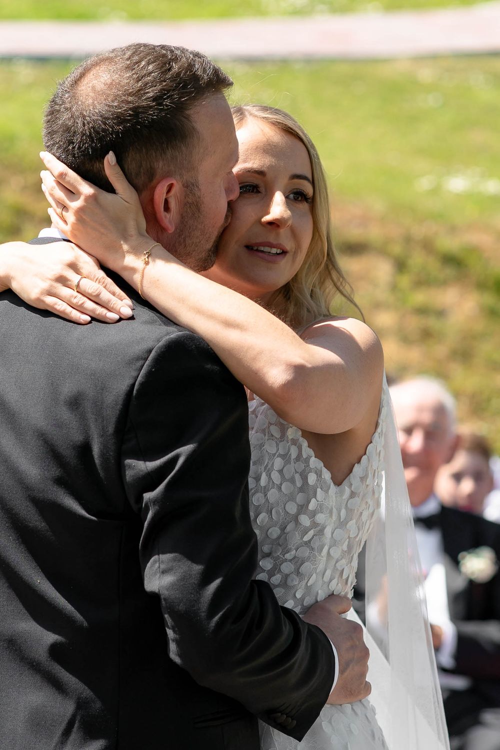 Bride cuddling Groom during ceremony at Sandy Cove Hotel Wedding