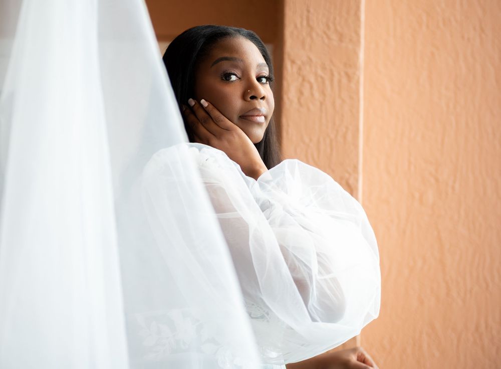 Natural light touches the bride on her hotel suite balcony.