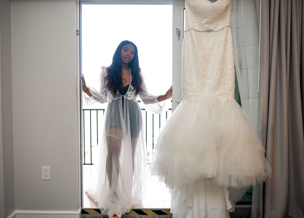 The natural light engulfs the bride as she touches her dress.
