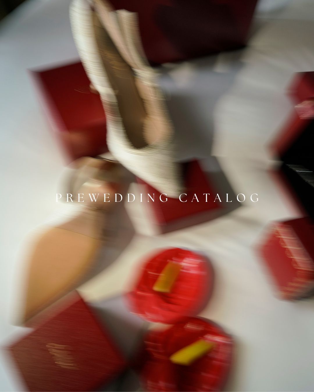 Blurred motion shot of a bride surrounded by red gift boxes for a prewedding catalog shoot.