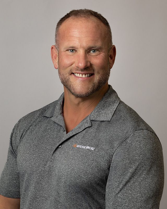 Corporate team headshot for Ritchie Bros. Auctioneers sales staff, grey backdrop