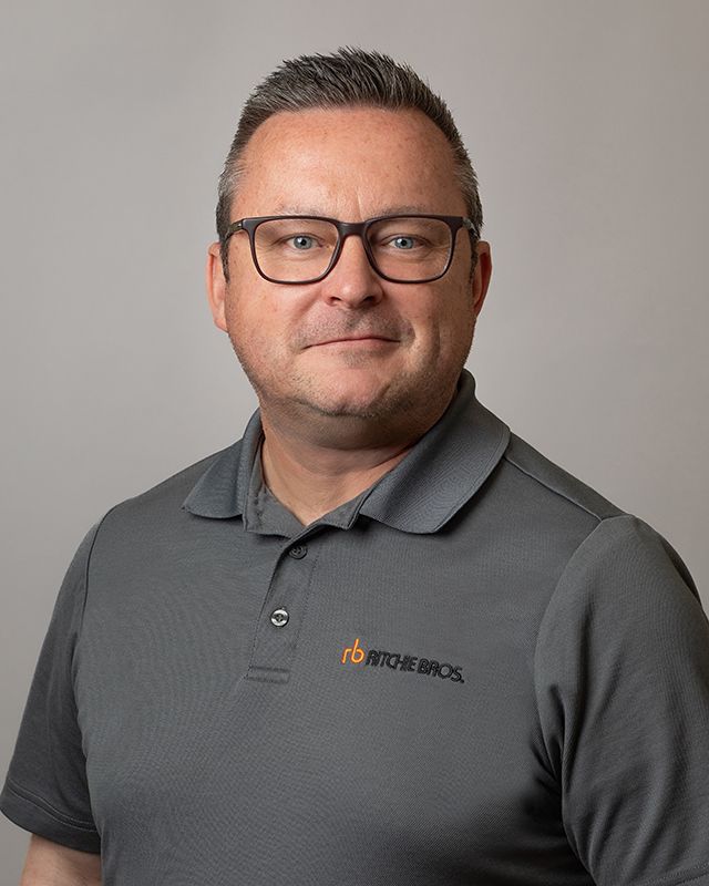 Corporate headshot of Ritchie Bros. Auctioneers sales staff, modern studio portrait
