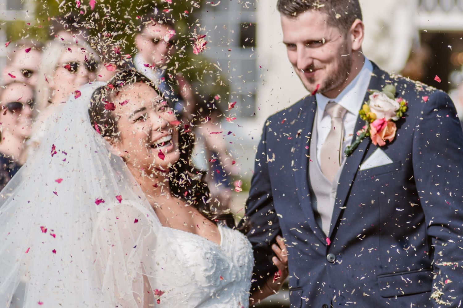 Bride and groom share their first dance in an elegant ballroom with arched windows and floral decor at their wedding reception.